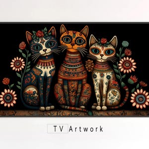 以下が含まれることがあります： 黒い背景に、カラフルな模様と花が描かれたスタイリッシュな猫が3匹。猫は青い目をしており、花柄のヘッドバンドをしています。アートワークは暗いフレームに入っています。