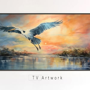 Puede incluir: Una pintura de una garza blanca volando sobre un lago al atardecer. La garza tiene un cuello largo y patas largas. El cielo es una mezcla de naranja, rosa y azul. El lago es de un azul oscuro con reflejos del cielo.