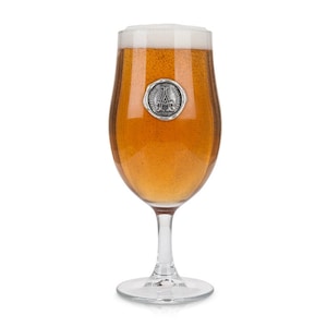May include: A clear glass beer stein with a pewter charm attached to the side. The charm features a letter "A" with a wreath around it.