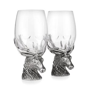 Puede incluir: Dos copas de vino de vidrio transparente con bases de cabeza de ciervo de peltre. Las cabezas de ciervo tienen cuernos y caras detalladas.