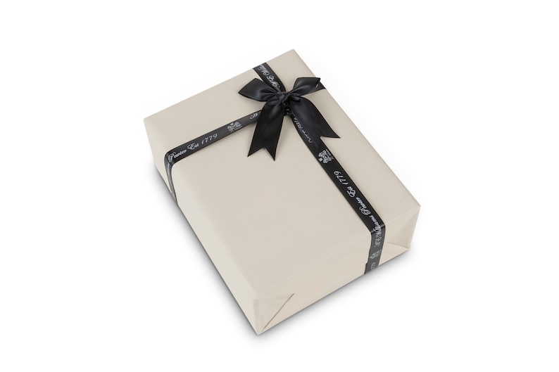May include: A beige gift box with a black ribbon tied in a bow. The ribbon has the text "Fortnum & Mason Est 1779" printed on it.