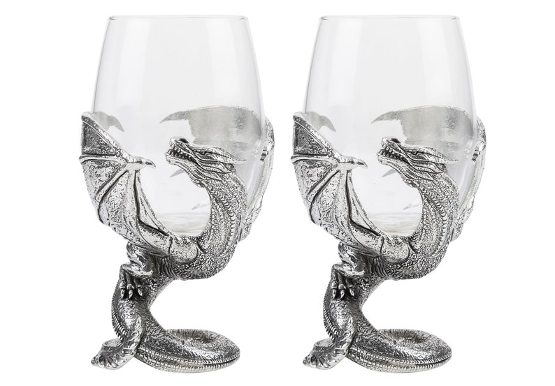 May include: Two silver dragon wine glass holders with clear glass goblets. The dragons are in a rearing pose with wings outstretched.