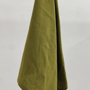 May include: A folded olive green linen kitchen towel hanging on a wooden rod.