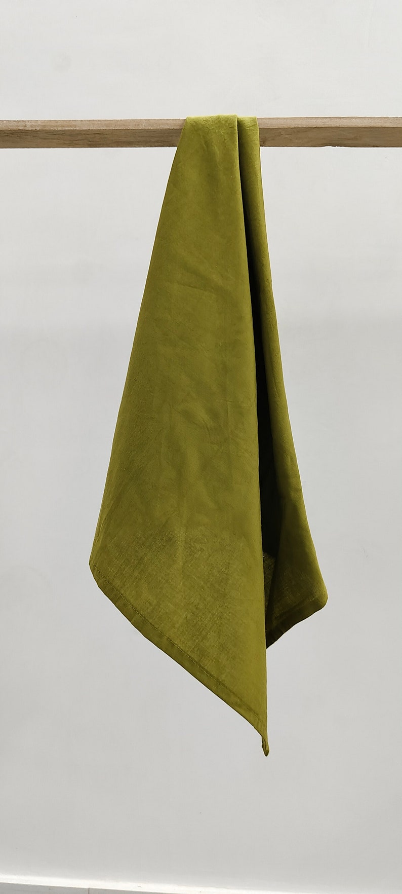 May include: A green linen kitchen towel hanging on a wooden rod.