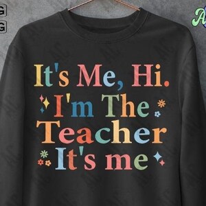 May include: Black sweatshirt with the text "It's Me, Hi. *I'm The* Teacher *It's me*" in rainbow colours.