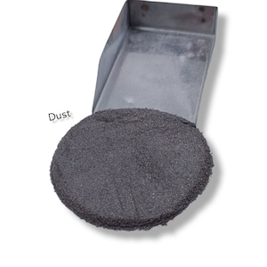 Puede incluir: Primer plano de un montón de polvo negro en una bandeja de metal. El polvo está etiquetado como "Polvo".