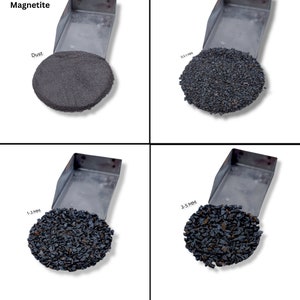 Pode incluir: Quatro amostras de magnetita, um mineral de óxido de ferro preto, em diferentes tamanhos: pó, 0,5-1 mm, 1-3 mm e 3-5 mm. As amostras são exibidas em bandejas de metal sobre um fundo branco.