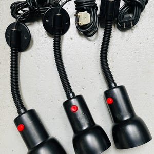 May include: Three black flexible-arm lamps with red buttons. Each lamp has a black cord and a round base.