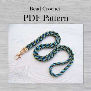 May include: A beaded lanyard with a gold clasp. The lanyard is made with blue, black, and gold beads in a braided pattern. The text "Bead Crochet PDF Pattern" is at the top of the image.