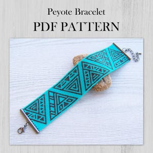 Può includere: Un MODELLO PDF per bracciale Peyote con un design geometrico a triangoli turchesi e neri. Il bracciale di perline presenta barre terminali in metallo e una chiusura a moschettone. Il testo Peyote Bracelet PDF PATTERN è visibile sopra l'oggetto.