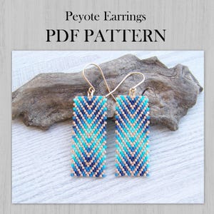 Könnte beinhalten: Rechteckige Peyote-Ohrringe mit Zickzackmuster in Blau-, Türkis- und Goldtönen. Die Ohrringe hängen an goldfarbenen Ohrhaken. Der Text "Peyote Earrings PDF PATTERN" ist oben im Bild zu sehen.