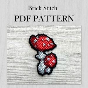 May include: A red and white mushroom with white spots, beaded in brick stitch. The mushroom is on a wooden background. The text "Brick Stitch PDF PATTERN" is above the mushroom.