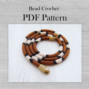 May include: A brown, black and white beaded snake necklace with a gold snake head clasp. Bead Crochet PDF Pattern.