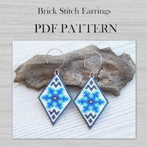 Op de afbeelding: Een paar blauwe en witte kralen oorbellen met een ruitvorm en een bloemenmotief. De oorbellen zijn gemaakt met brick stitch en hebben zilveren haakjes. PDF PATTERN.