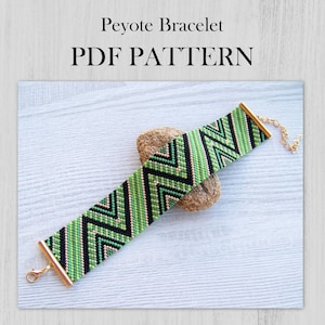 Peut inclure: Bracelet en point de peyote vert, noir et or avec un motif en chevron. Le bracelet est sur une surface en bois et a un fermoir en or. MODÈLE PDF.