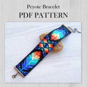 Puede incluir: Un brazalete de punto de peyote colorido con un patrón geométrico y diseños de plumas. El brazalete está hecho con cuentas negras, azules, naranjas y blancas. El brazalete tiene cierres plateados y se muestra sobre una superficie de madera. PDF PATTERN.