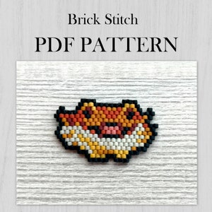 Puede incluir: Un patrón PDF para un sprite de zorro de cuentas en punto de ladrillo. El zorro es naranja, amarillo, blanco, negro y rosa.