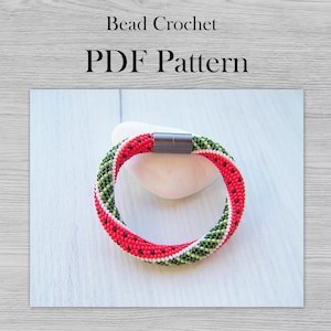 Puede incluir: Un brazalete de cuentas rojas, verdes y blancas con un diseño de sandía. El brazalete tiene un cierre magnético y está hecho con cuentas de semillas pequeñas. Patrón de crochet de cuentas PDF.