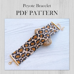 Peut inclure: Un modèle PDF de bracelet Peyote avec un motif de perles imprimé léopard en marron, noir et beige. Le bracelet est doté de barres d'extrémité en métal doré et d'une chaînette d'extension dorée avec un fermoir mousqueton à une extrémité.
