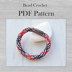 May include: A beaded bracelet with a black, white, red, and beige checkered pattern. The bracelet has a magnetic clasp and is made with small seed beads.