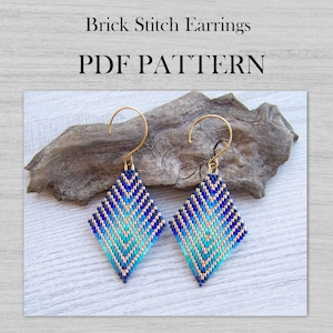 Peut inclure: Une paire de boucles d'oreilles en point de brique bleu et or de forme losange. Les boucles d'oreilles sont sur une surface en bois. PDF PATTERN.
