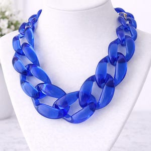 Collana vistosa, blu trasparente con maglie grandi. Collana da donna stravagante, gioiello moderno e accattivante.