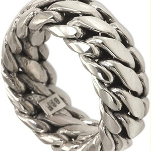 May include: A silver ring with a thick, chunky chain design. The ring is made of a single piece of metal and has a smooth, polished finish.