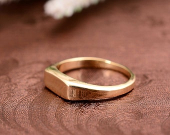 Könnte beinhalten: Ein goldener Siegelring mit einer flachen, rechteckigen Oberseite.