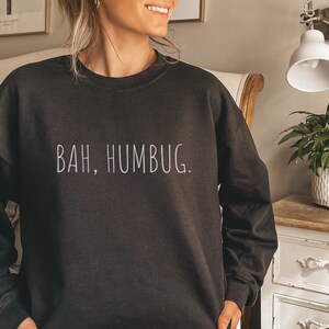 May include: Black sweatshirt with the text "BAH, HUMBUG." printed in white on the front.