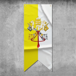 Puede incluir: Una bandera vertical amarilla y blanca con un escudo de armas que presenta una triple corona y llaves. La bandera está colgada en una pared gris texturizada.