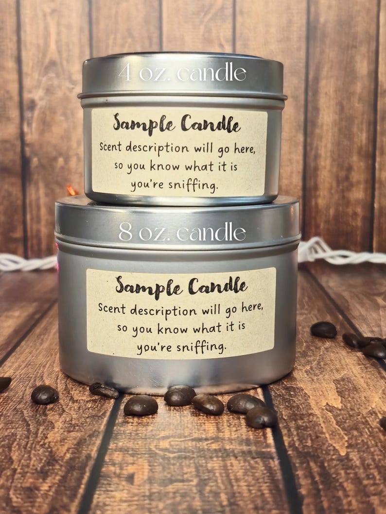 May include: Two silver candle tins with labels that say "Sample Candle" and include the text "Scent description will go here, so you know what it is you're sniffing." The smaller tin is labeled "4 oz. candle" and the larger tin is labeled "8 oz. candle".