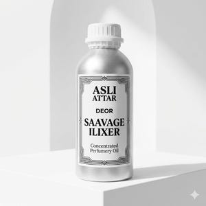 Może przedstawiać: Srebrna butelka olejku perfumowanego z białą zakrętką. Etykieta głosi "ASLI ATTAR DEOR SAAVAGE ILIXER Concentrated Perfumery Oil" w ozdobnej ramce. Butelka stoi na białej powierzchni.