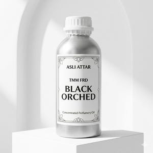 May include: A silver-coloured bottle with a white cap and a label that reads "ASLI ATTAR TMM FRD BLACK ORCHED Concentrated Perfumery Oil." The bottle is cylindrical and sits on a white surface.