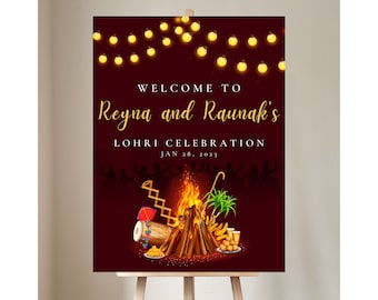 May include: A red and gold welcome sign for a Lohri celebration for Reyna and Raunak. The sign features a bonfire with traditional Indian decorations, including a dhol drum, a kite, and a sugarcane stalk. The text on the sign reads "Welcome to Reyna and Raunak's Lohri Celebration Jan 28, 2023".