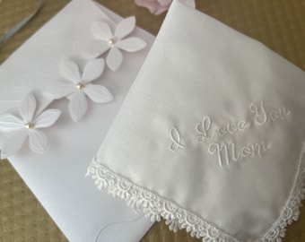 Embroidered “I Love You Mom” hanky will bring tears of joy to Mom. Made with delicate lace edging and comes with gift giving adorable pouch!