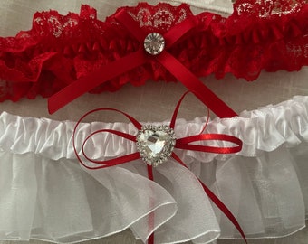Simply elegant 2 piece garter set! Lovely set comes with keepsake garter with heart rhinestone and red toss garter. Boxed for gift giving.
