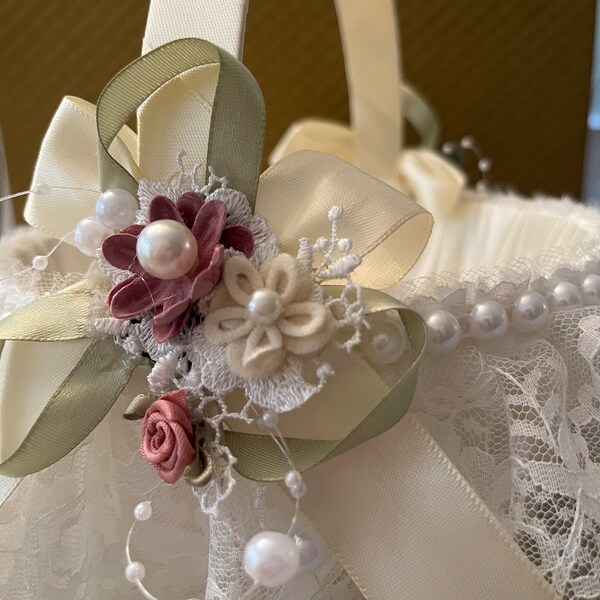 Simply sweet ivory flower girl basket. Soft flowers, pearls and lace adorn this beautiful basket. Your flower girl will love it!