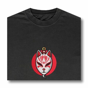 May include: Black t-shirt with a red circle and a white fox mask with a sword through it.