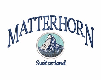 Può includere: Un disegno ricamato con la parola MATTERHORN in testo blu scuro arcuato sopra un emblema circolare. L'emblema raffigura una cima di montagna con cielo azzurro e alberi blu scuro. La parola Switzerland si trova sotto l'emblema.