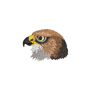 Può includere: Una toppa ricamata raffigurante il profilo di una testa di falco. L'uccello presenta piume marroni e color cuoio sulla sommità del capo, un becco nero appuntito con base gialla, un occhio chiaro con pupilla scura e piume bianche testurizzate.