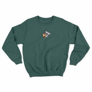 May include: A dark green sweatshirt with a small embroidered design of a koala holding a cup of boba tea.