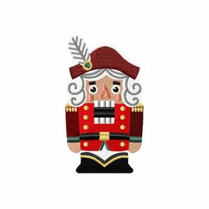 May include: Embroidered image of a traditional nutcracker soldier. The nutcracker is dressed in a red jacket with gold buttons, a black belt, and a burgundy hat with a feather. The soldier has white curly hair and a stern expression.