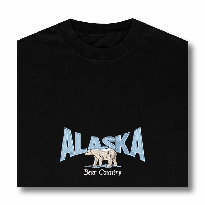 May include: Black t-shirt with a blue and white graphic of a polar bear walking on ice with the text "Alaska Bear Country" underneath.