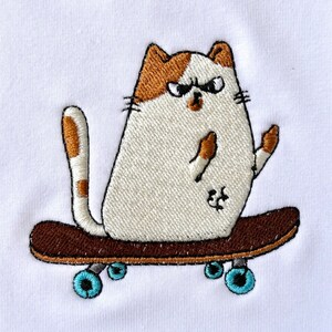 Op de afbeelding: Een witte kat met bruine en oranje markeringen rijdt op een bruin skateboard met blauwe wielen. De kat heeft een boze uitdrukking op zijn gezicht.