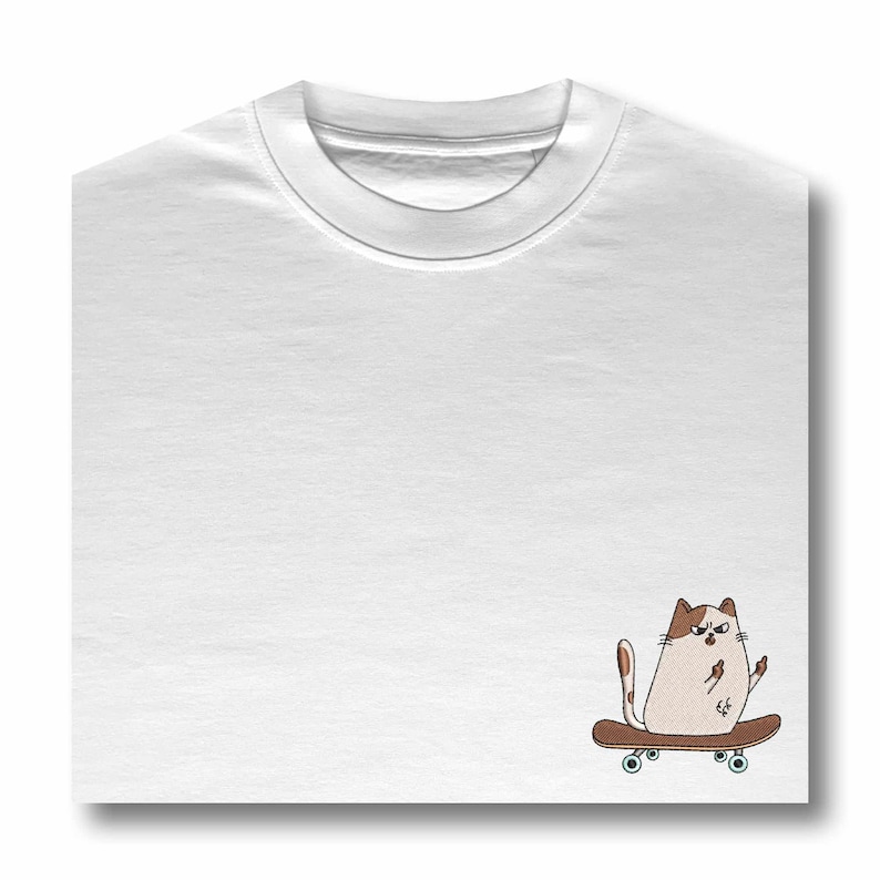 Op de afbeelding: Wit T-shirt met een bruin-witte kat die skateboardt op de rechterkant van het shirt.
