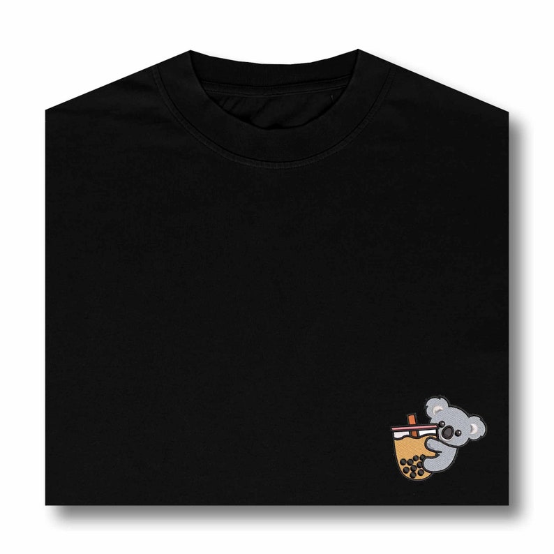 May include: Black t-shirt with a small embroidered design of a koala holding a cup of boba tea.
