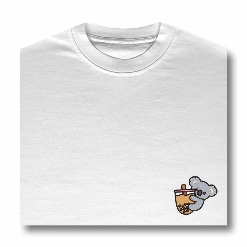 May include: White t-shirt with a cartoon koala drinking boba tea.