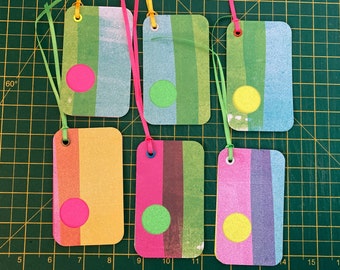 6 modern, layered gift tags. Simple, bright and ready strung with satin ribbon. Pink, orange, yellow, green and purple. Very sparkly.