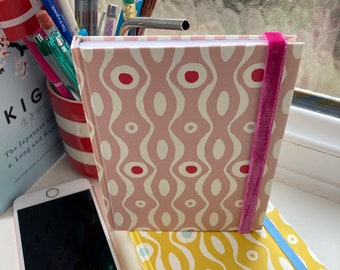 Stocking filler A6 handmade, hardback pocket-sized pink or yellow notebook, blank, white 120gsm paper, and elastic fastener.