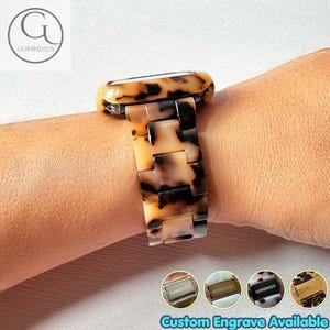 May include: A watch band featuring a tortoiseshell pattern with brown and tan resin links. The band has a rectangular connector and a smooth finish. Four small circular thumbnails at the bottom display metal clasps with the text GOBANDZUS.
